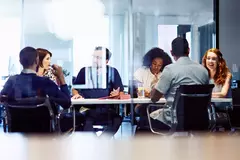 Group of colleagues sitting in a meeting room.