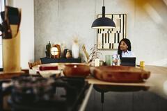 Man looking serious, sitting at a kitchen table with tablet.