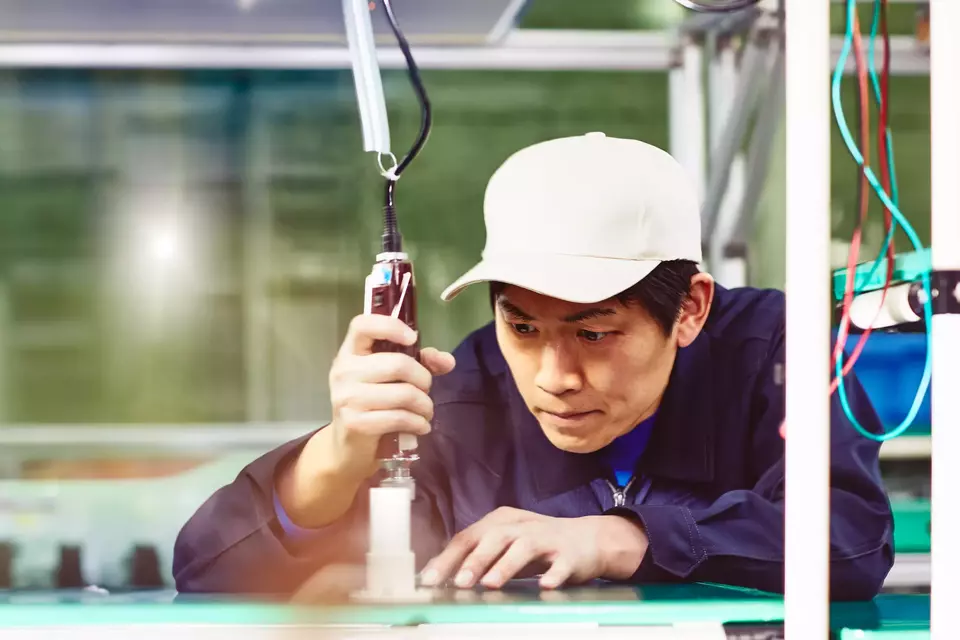 male wearing a white hat working with tools on a production site

